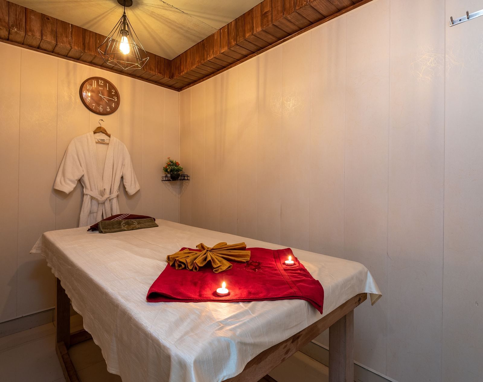 View of the massaging table with a bathrobe hung near the pillow at DLS Highland Resort and Spa, Mussoorie.